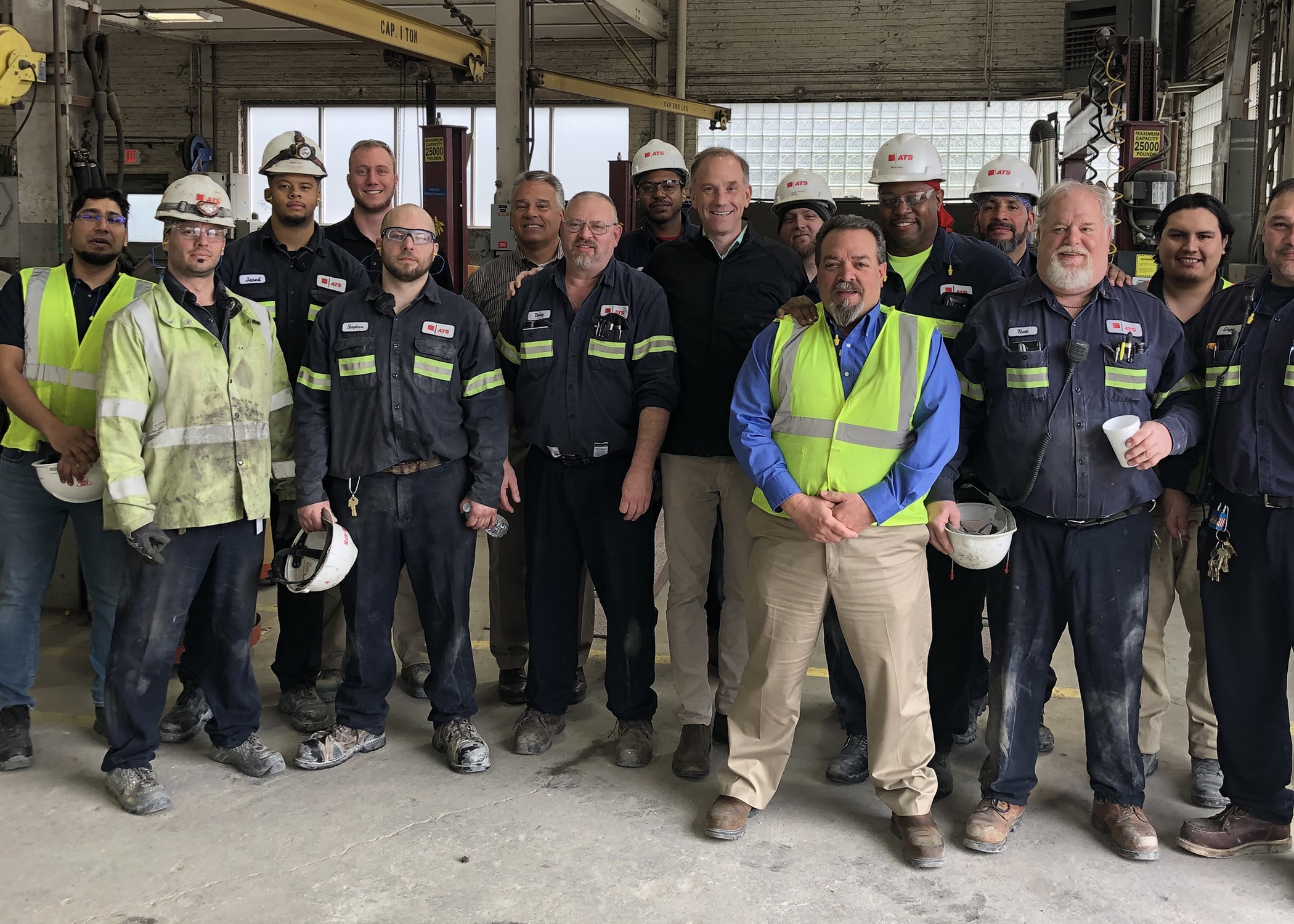 Jeff Owens standing with 15 employees in plant.