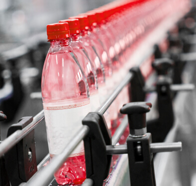 Water bottles with red cap lined up in factory