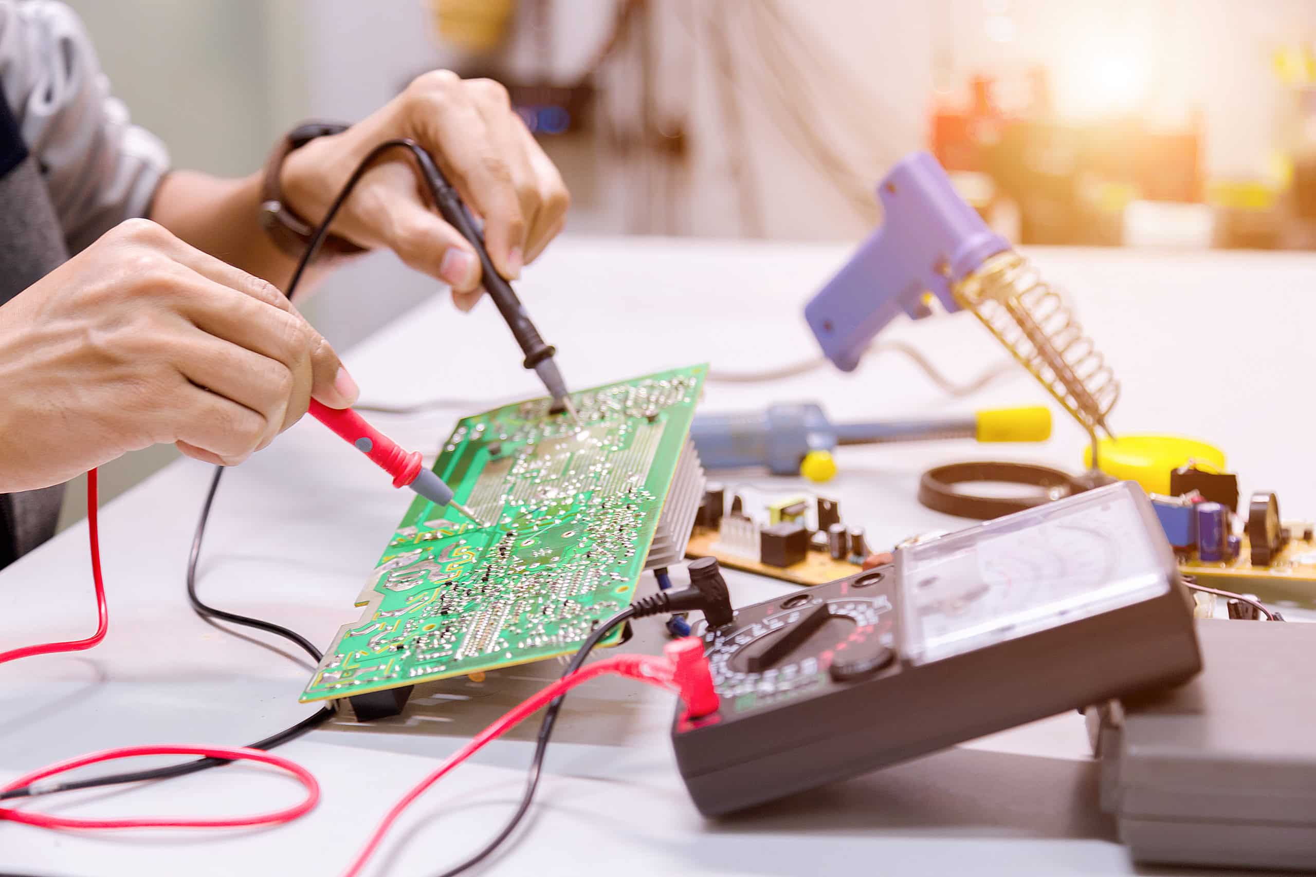 Two hands repairing motherboard.