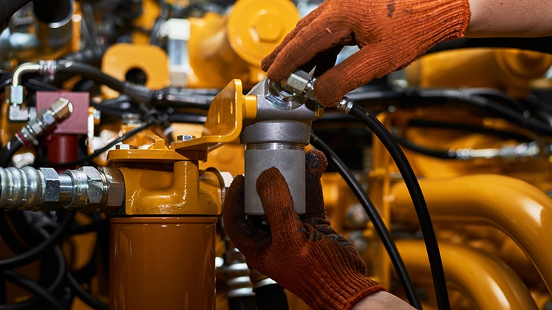 Two gloved hands adjusting machinery.