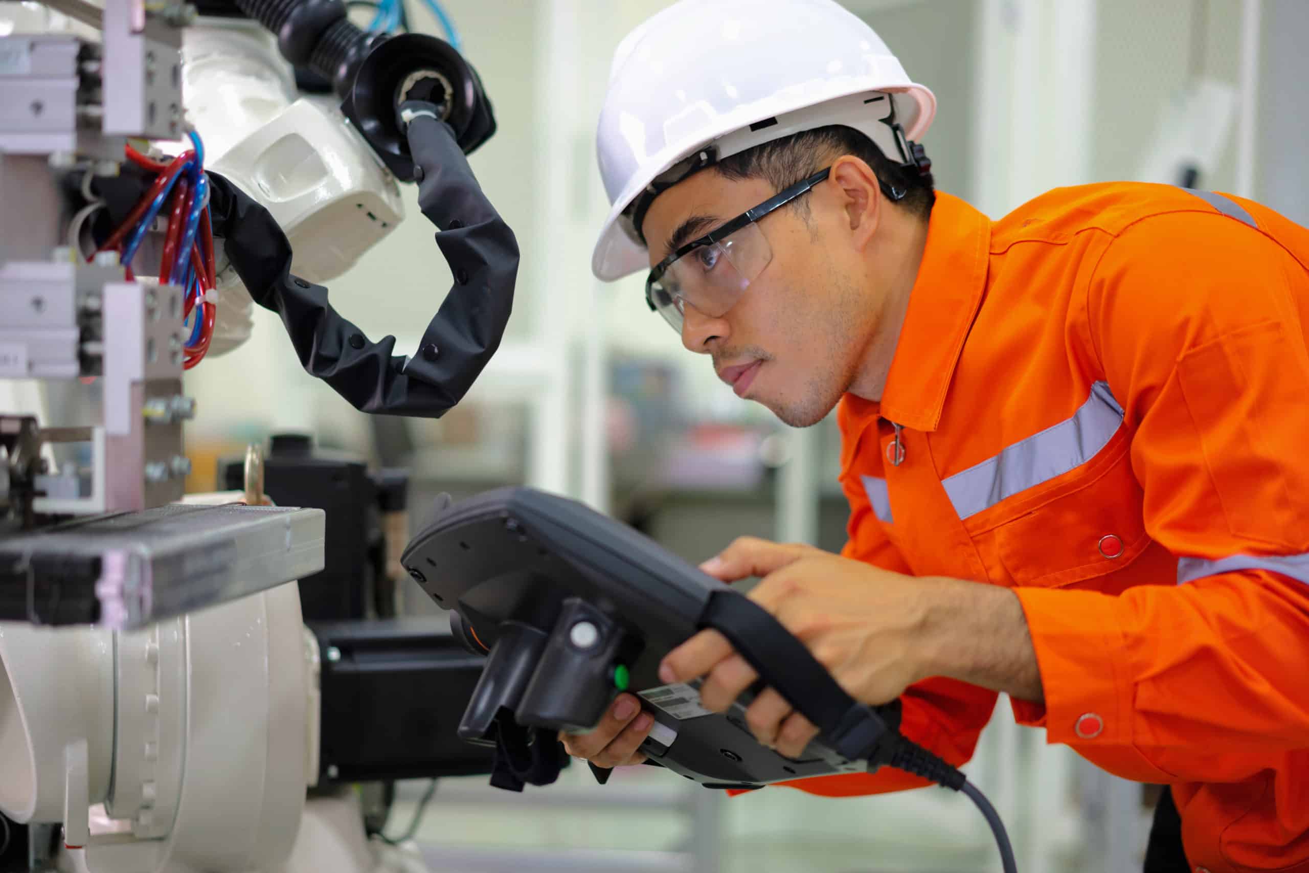 Man in hard hat using handheld controller.