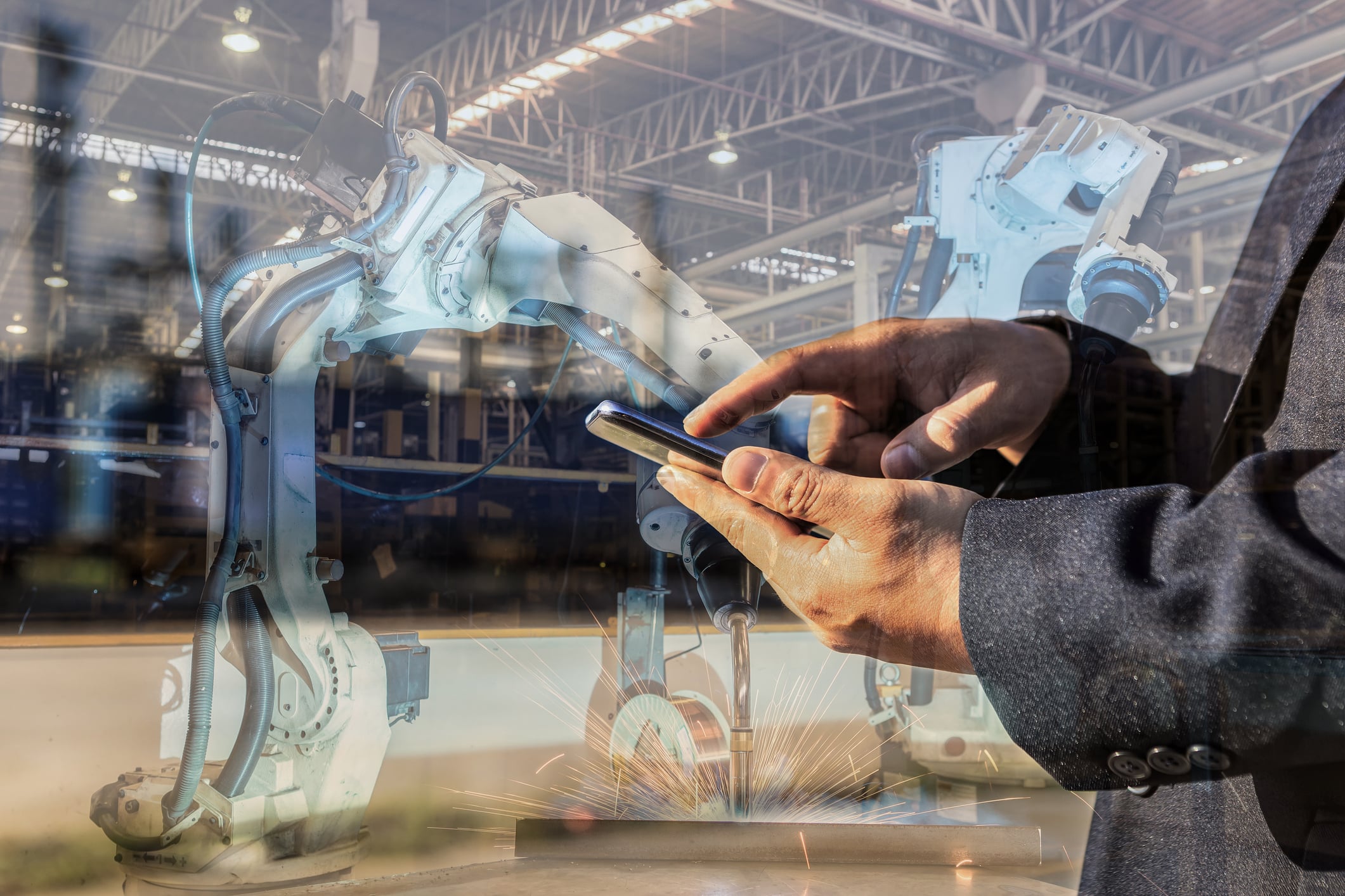 Man using smart phone controlled robotic arm.