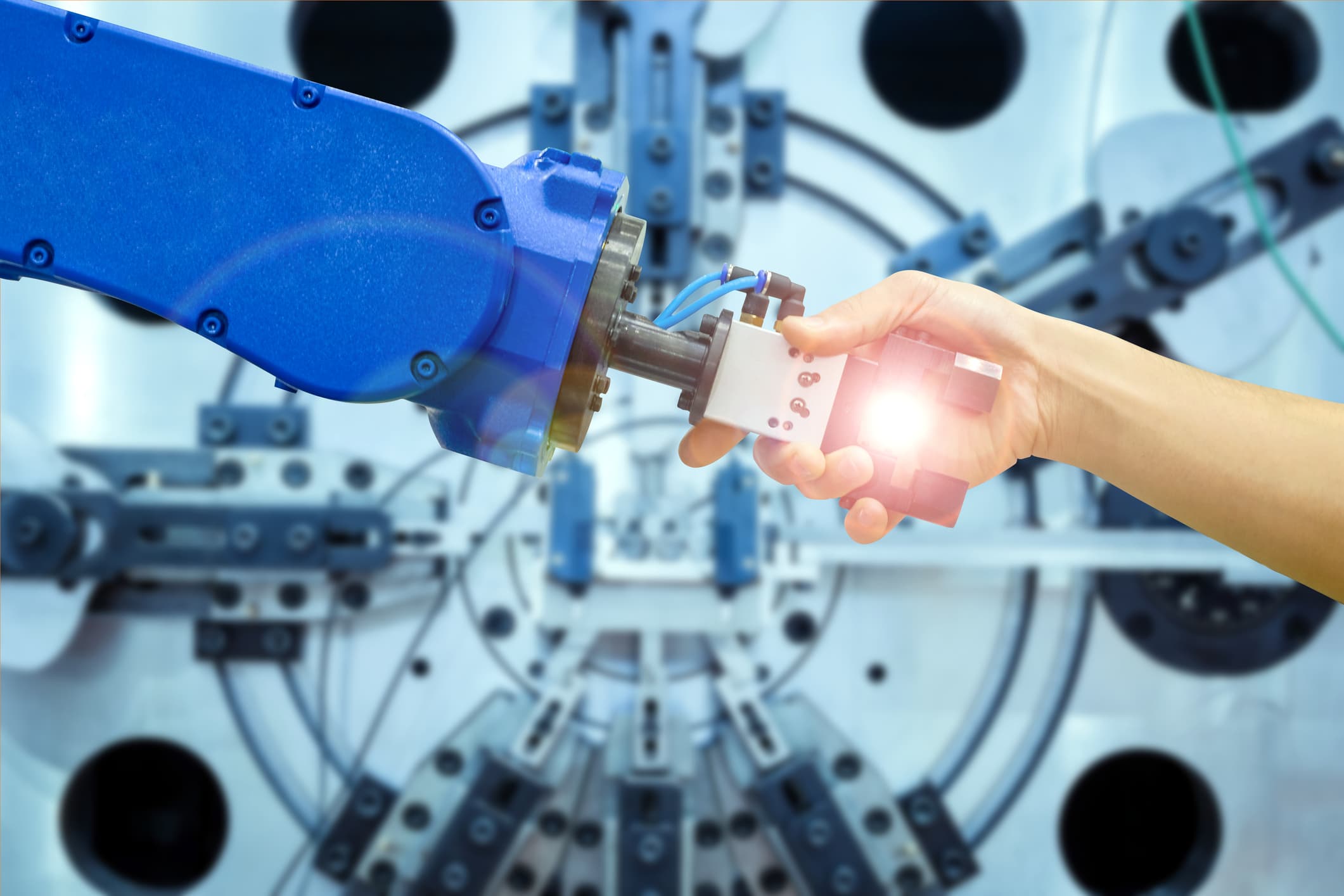 Industrial robot shaking human hand.