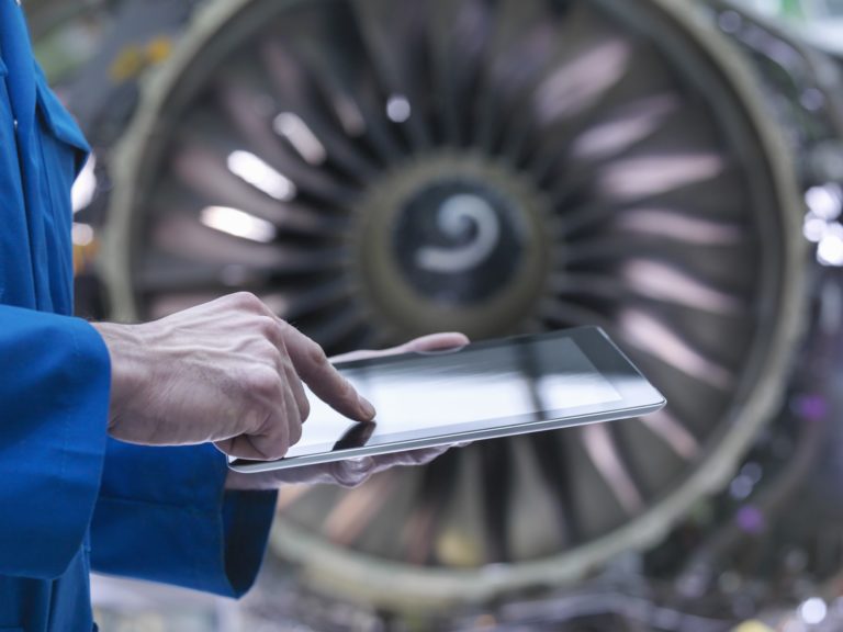 Aerospace engineer using ipad in factory.