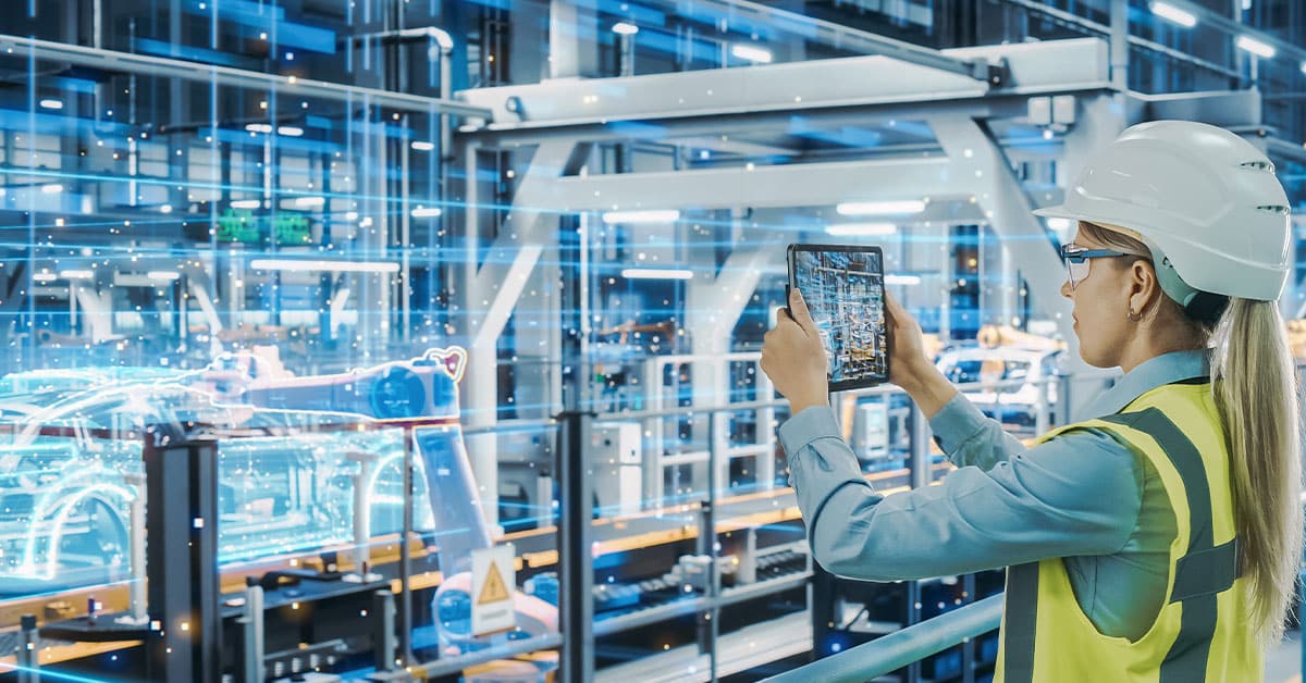 Female Automotive Engineer Using Augmented Reality Tablet Computer to Scan Automated Robot Arm Assembly Line.