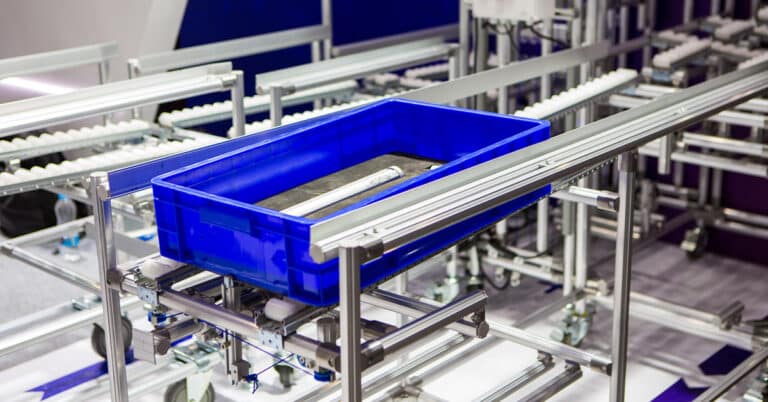 Blue tray of material parts on conveyor.