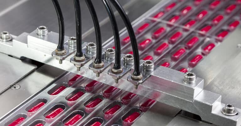 Red pills on a production line in a pharmaceutical manufacturing facility.