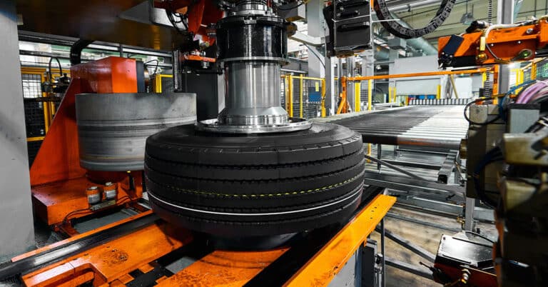 Tire with deep protector and marking on conveyor at plant.
