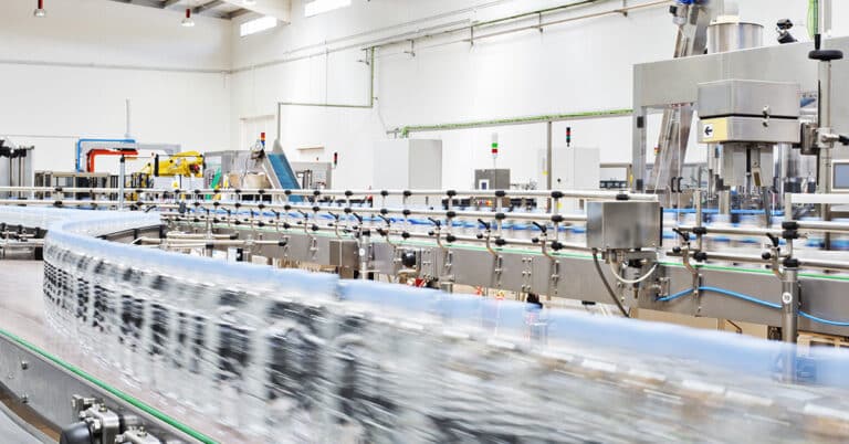 Bottles on conveyor belt in factory.