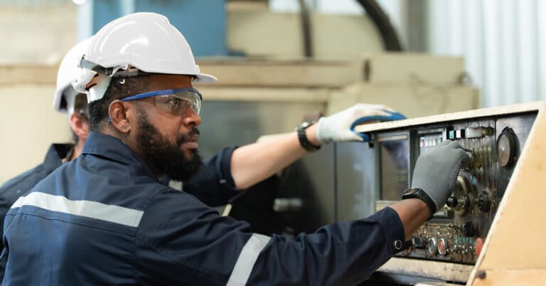 Two engineers repairing a legacy piece of equipment to return to normal operation.