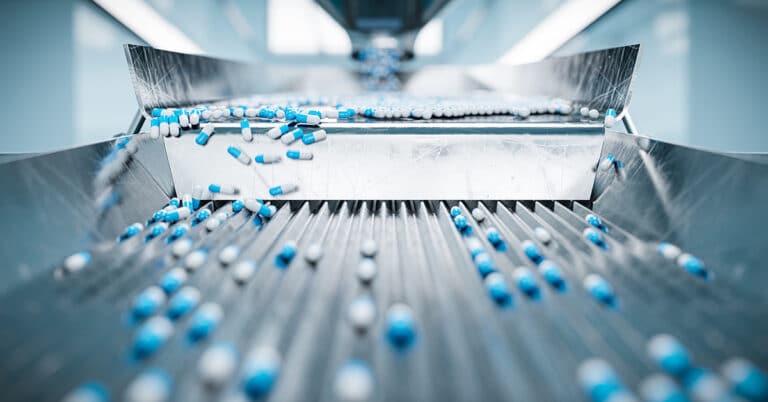 Pharmaceutical capsules on a sorting machine in a production line.