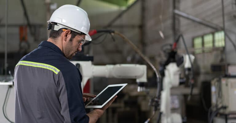 Male automation engineer using tablet in an industrial factory.