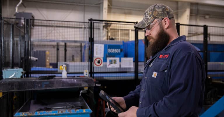 ATS maintenance technician reviewing work order on tablet computer.