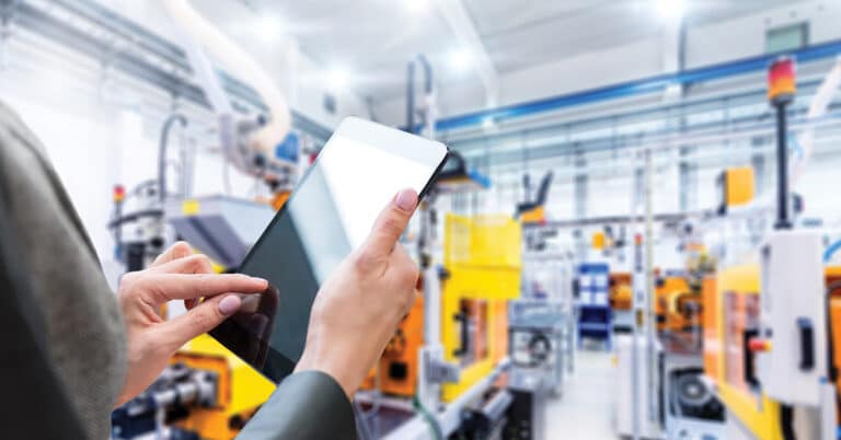Women working with a digital tablet in modern manufacturing environment.