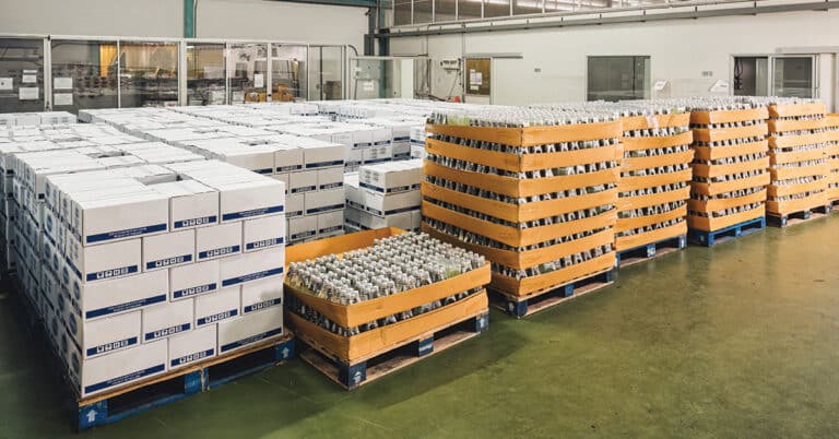 Group of bottled juice beverage product in cardboard box package in manufacturing factory for shipping.