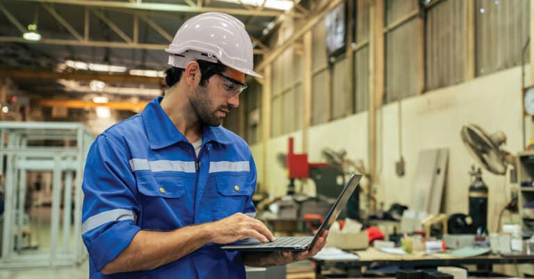 Industry worker in factory, using technology.