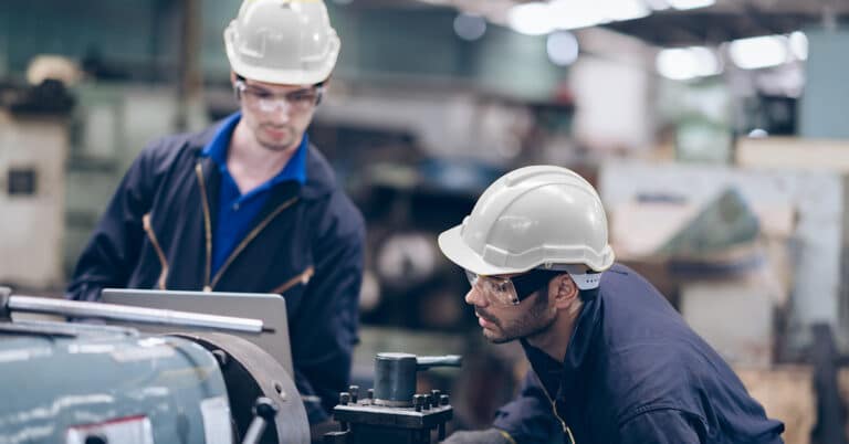 Two worker in production line as working at heavy machine.