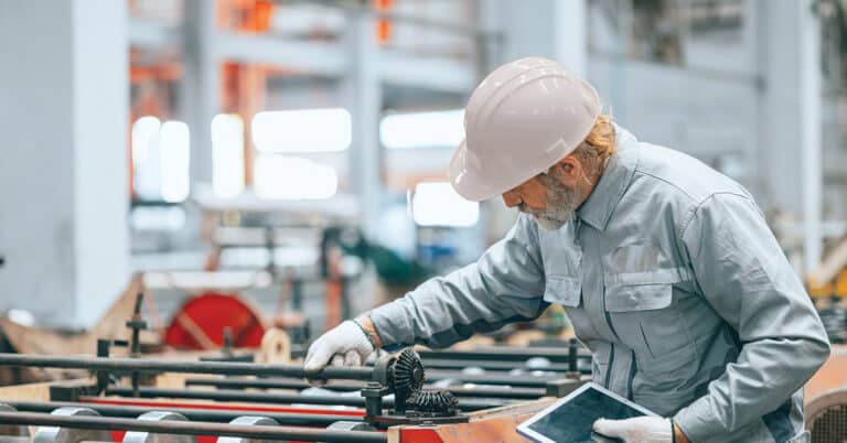 Professional senior Industrial worker in protective helmet and uniform service machinery in factory, expert engineer technician maintenance heavy machine plant line production.