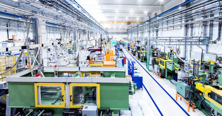 Industrial aisle surrounded by modern machines which having busy robotic arms with molding shapes and producing plastic pieces for variety of industry